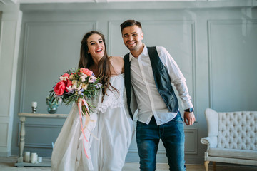 Cheerful bride and groom having fun together. Newlyweds laughing and go crazy. Artwork. Wedding...