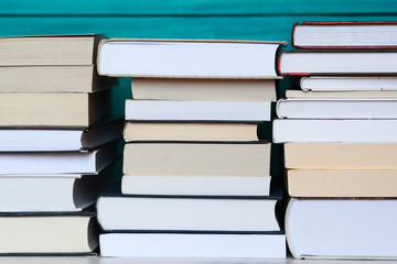 Stacks of books with wooden blue background.