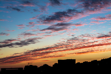 Sunset over a big city. Panorama sunset over the roofs of city houses.