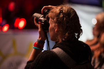 Girl photographer takes picture at a concert. Photography concept