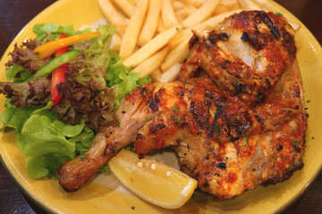 Flame grilled spicy chicken with chips and fresh salad 