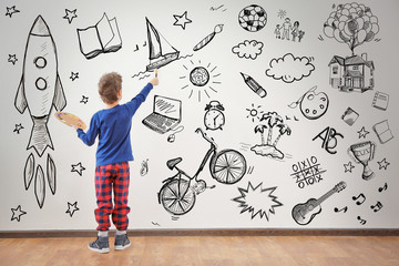 Cute little boy painting on wall in empty room - obrazy, fototapety, plakaty