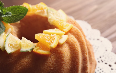 Delicious citrus cake with sliced fruits on table, closeup