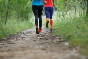 Two running sportswomen in forest