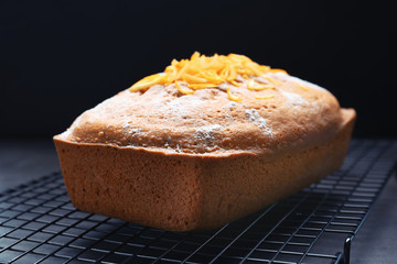 Grid with delicious citrus cake and zest on table