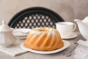 Plate with delicious citrus cake and zest on table