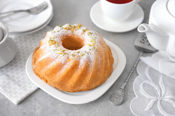 Plate with delicious citrus cake and zest on table