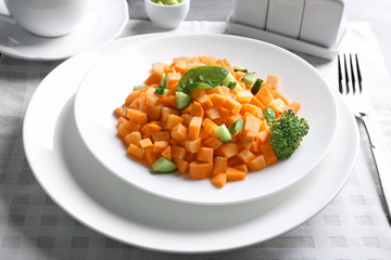 White round plate with delicious carrot salad on table