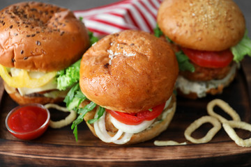Tasty turkey burgers on wooden board