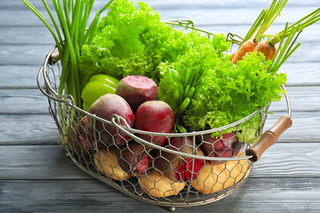 Fresh beets with vegetables in metal basket on table