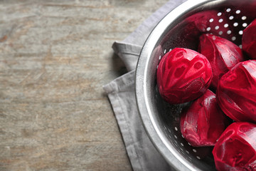 Peeled beets in strainer on table
