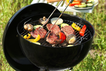 Cooking tasty meat and vegetables on barbecue grill outdoors