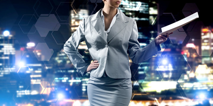 Close of businesswoman against night cityscape background and technology concept