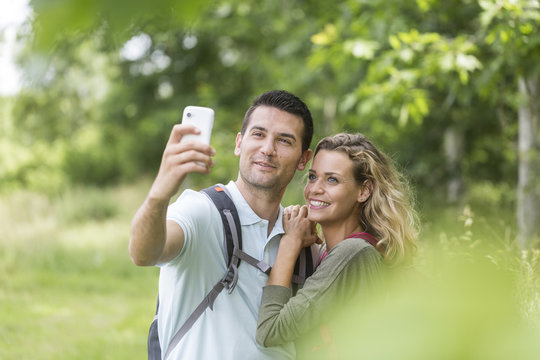 Young couple on a rambling making pictures of themeselves with a smartphone