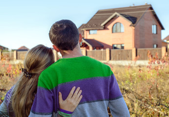 Rear view of young couple looking at their new house