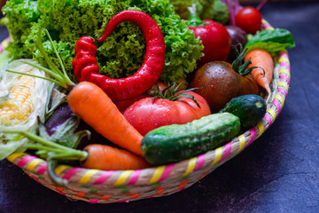 Part of big Basket with different Fresh Farm Vegetables on the dark concrete background. Harvest. Food or Healthy diet concept.Vegetarian.Copy space for Text, .selective focus.
