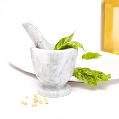Making pesto with white and gray mortar and pestle