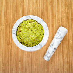 White and gray mortar and pestle making guacamole