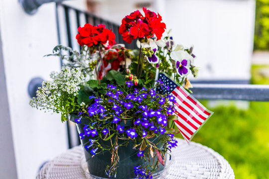 Patriotic Flower Pot With American Flags And Red And Blue Flowers On Porch
