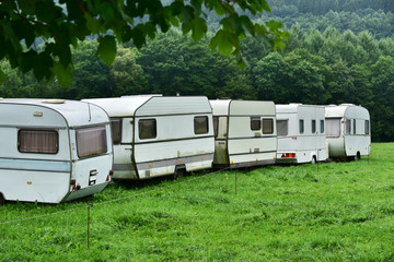 Parking with annuated camper trailers. Row of old-fashioned caravans on a campsite in the Belgian Ardennes.