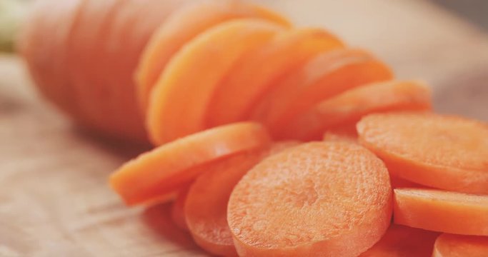sliced organic carrot on olive wood cutting board closeup  footage