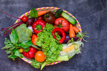Top view Big Basket with different Fresh Farm Vegetables on the dark concrete background. Harvest. Food or Healthy diet concept.Vegetarian.Copy space for Text, .selective focus.