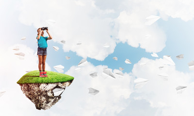 Concept of careless happy childhood with girl looking in binoculars