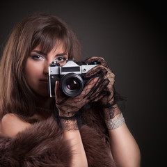 portrait of beautiful young retro woman holding vintage camera