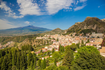 Obraz premium Panoramic view of beautiful town of Taormina, with green foreground and blue sky, Sicily island, Italy
