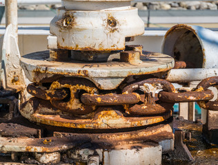 A large ship's rusty anchor chain winch