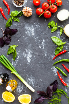 Fresh farmers organic market vegetable with copy space. Healthy lifestyle vegan food on dark black stone surface. Cherry tomatoes, Chile peppers, basil, onion, garlic. Ideas for restaurant menu
