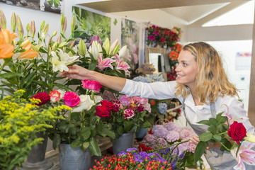 Gorgeous florist picking flowers to make a bouquet