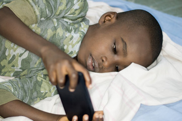 Child boy in bed with smartphone
