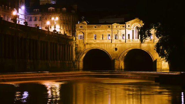 Pulteney Bridge and weir timelapse. Palladian bridge in Bath, Somerset, UK, with River Avon flowing underneath at night