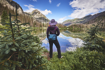 a young woman hiking next to a mountain lake