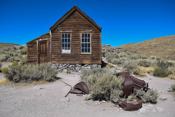Pieces of an old car, in front of an old house, in the historic ghost town, Bodie