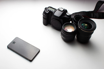group of camera lenses and a mobile phone on a white background
