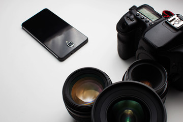 group of camera lenses and a mobile phone on a white background