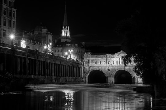Fototapeta Pulteney Bridge and weir at night black and white. Palladian bridge in Bath, Somerset, UK, with River Avon flowing underneath at night