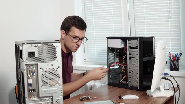 Computer service worker fixing broken computer in the office and upgrading computer hardware. Support team. 4k