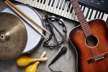 Fotobehang a group of musical instruments including a guitar, drum, keyboard, tambourine. © goodmanphoto