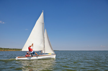 Two man drive a sport sailing yacht in competition