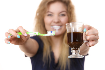 Happy woman holding toothbrush and coffee