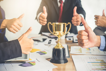 Businessman show thumbs up with trophy, reward, winner, champion and successful for business