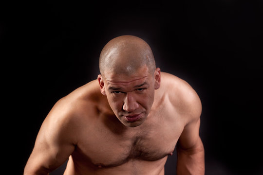 Muscular man topless in a threatening posture