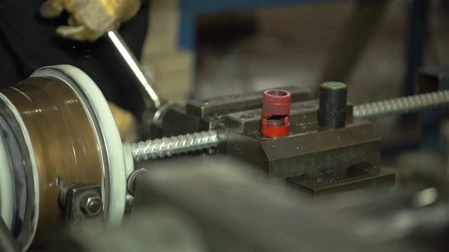 Worker Taking Steel Bar Out Of Machine - Front Angle 