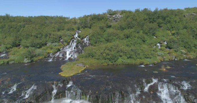 Rising over Hraunfoss lava spring waterfall glacial river Iceland drone aerial 4k