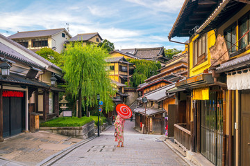 Fototapeta na wymiar Japanese girl in Yukata with red umbrella in old town Kyoto