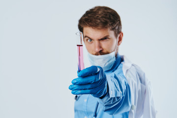 A man with a beard on a light background holds laboratory utensils, science, scientist