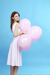Fototapeta na wymiar Woman on blue background holds balloons, smile, full-length